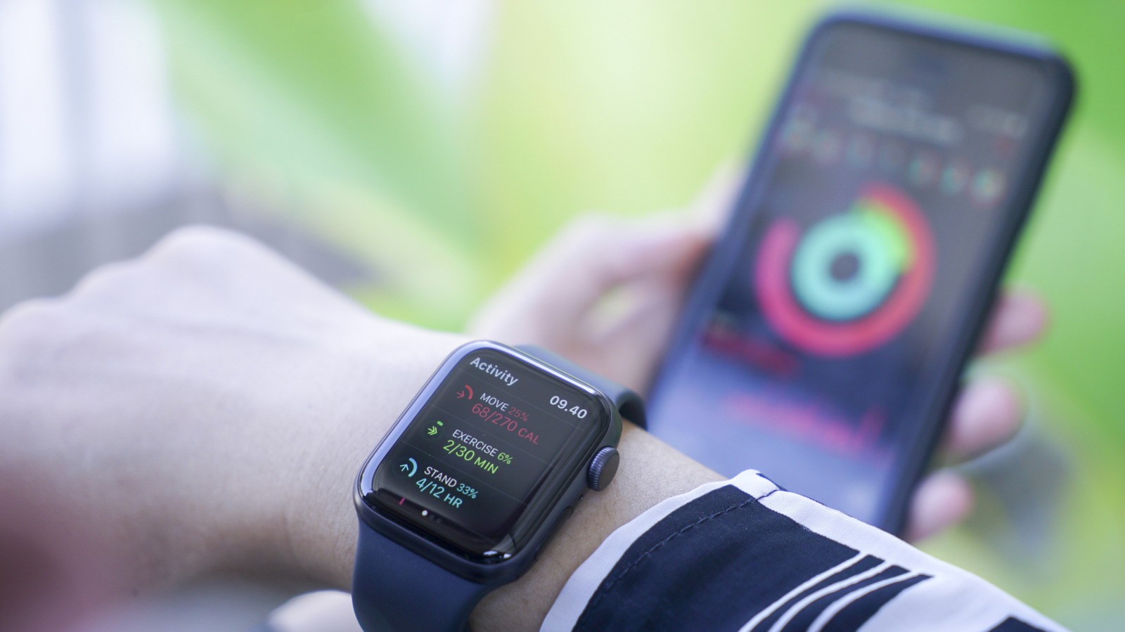 Smartwatch displaying activity metrics while a smartphone shows a colorful fitness tracking interface