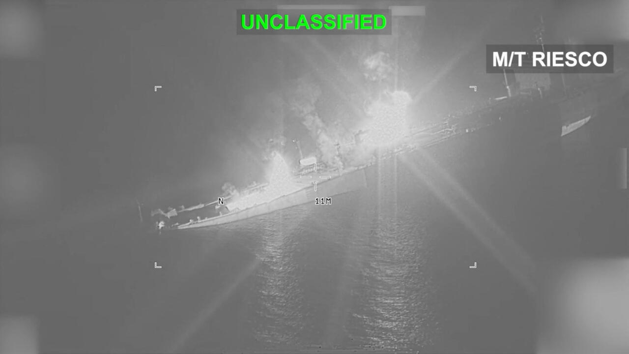 Infrared aerial view of a tanker at sea with bright flames or heat near its deck.