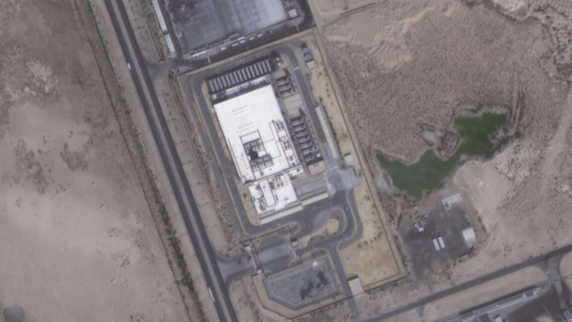 Aerial view of a large industrial facility surrounded by desert roads and small green ponds