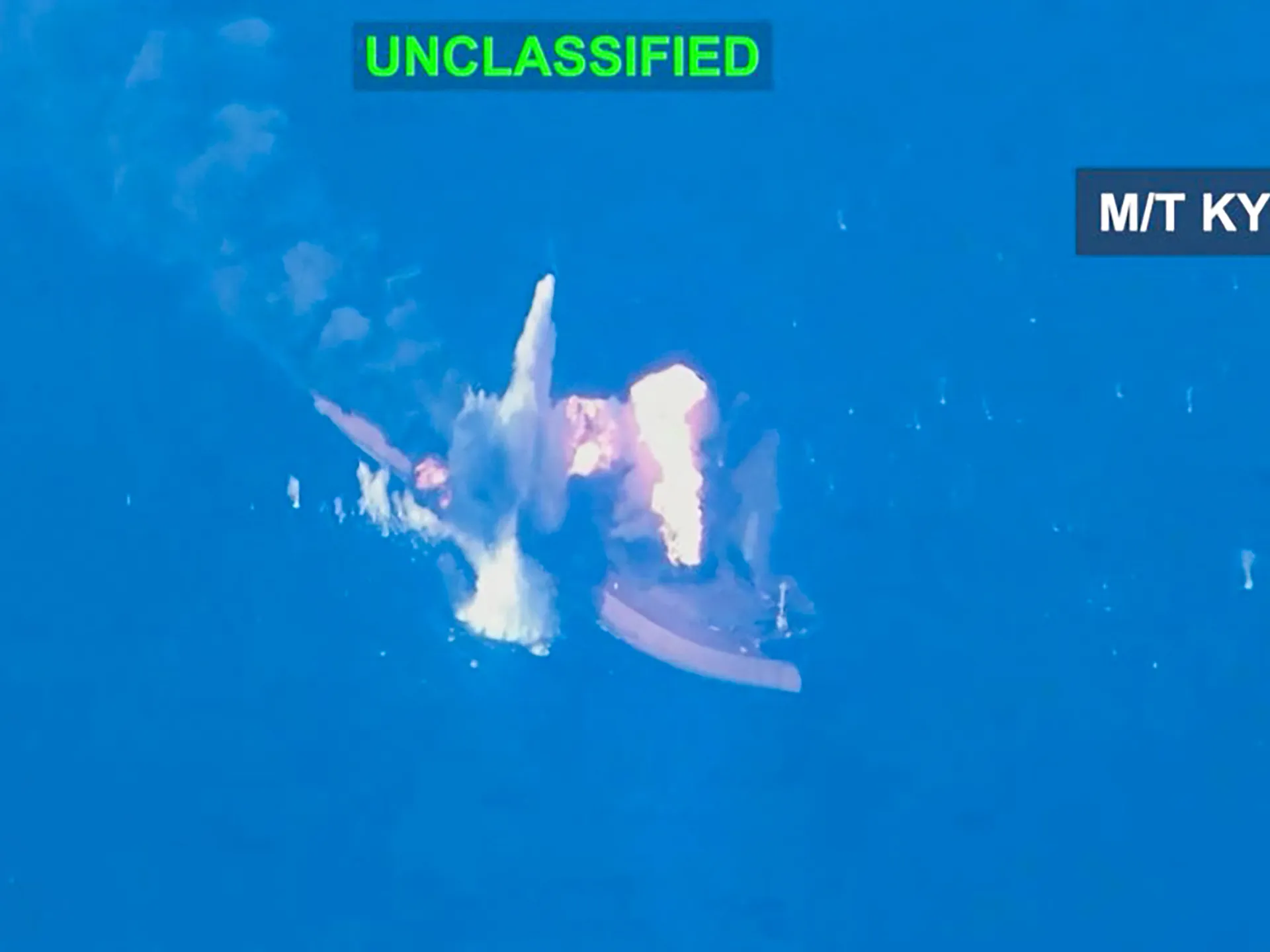 Blue-tinted footage shows a fiery explosion and debris on or near a vessel.