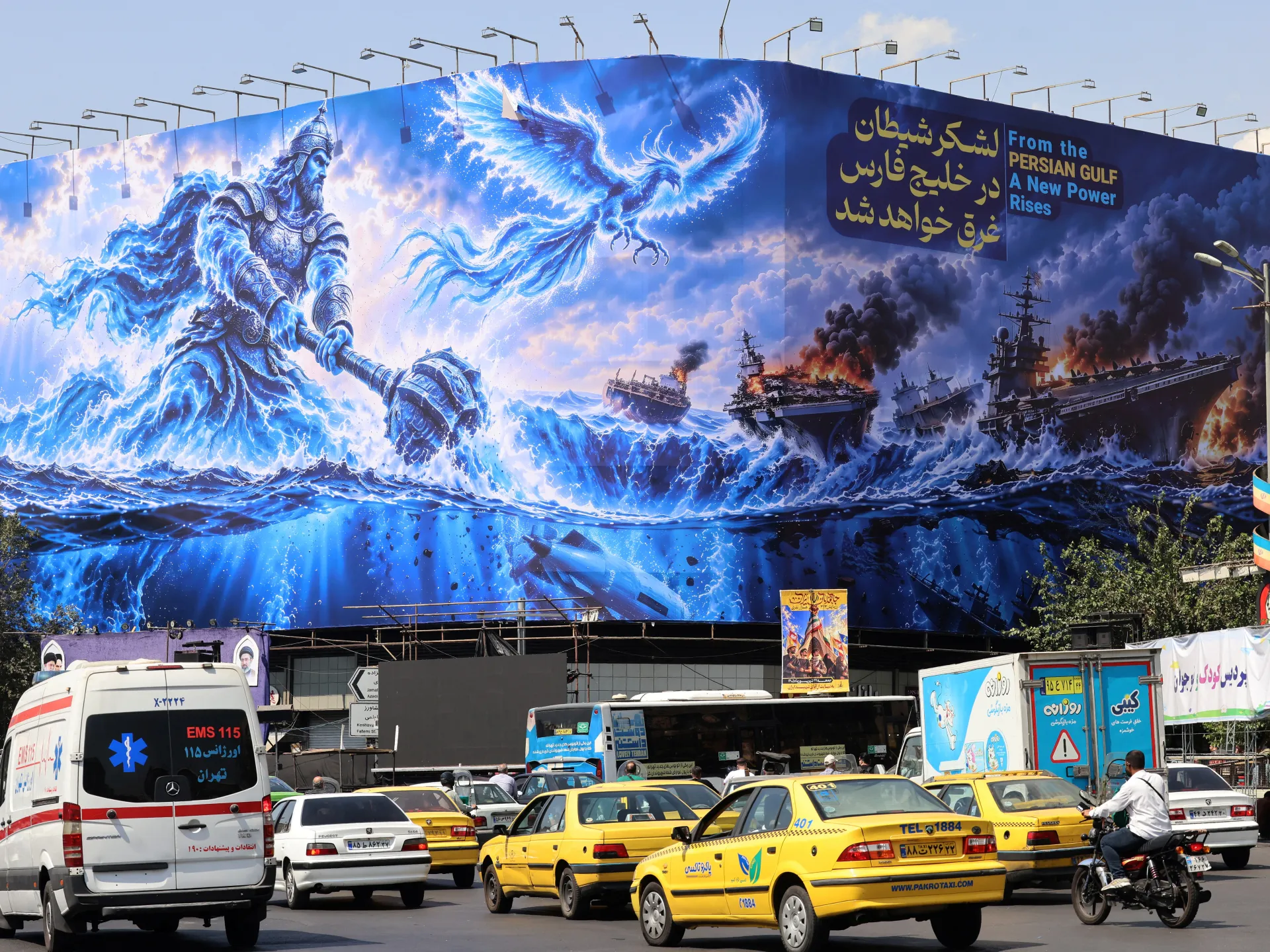 Large blue mural depicting a warrior, phoenix, burning warships, and Tehran traffic below