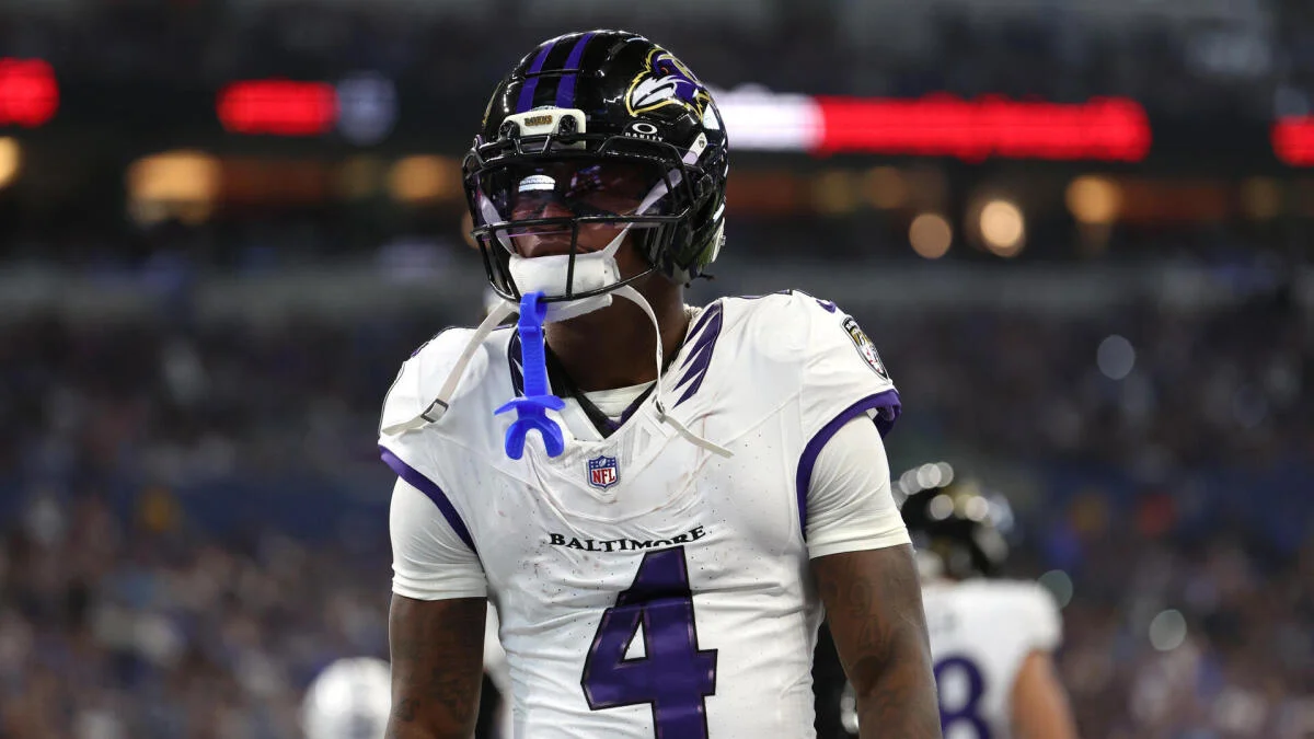 Baltimore Ravens player wearing a white number 4 jersey and black helmet stands on the field.