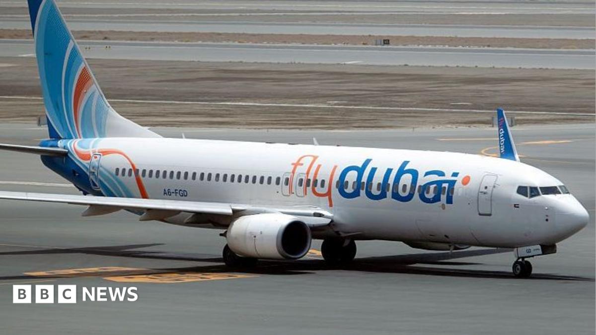A flydubai passenger jet taxis on an airport runway, with a BBC News logo in the lower-left corner.