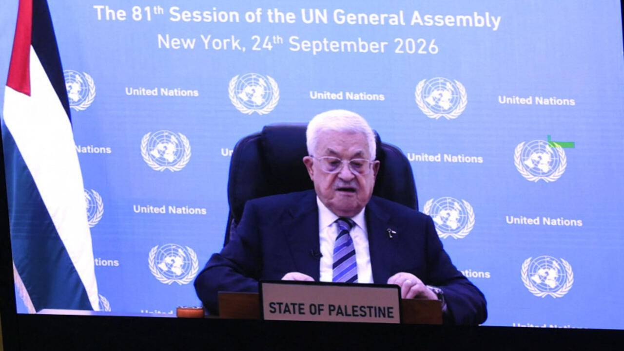 A suited man speaks at a lectern labeled State of Palestine before a United Nations backdrop.