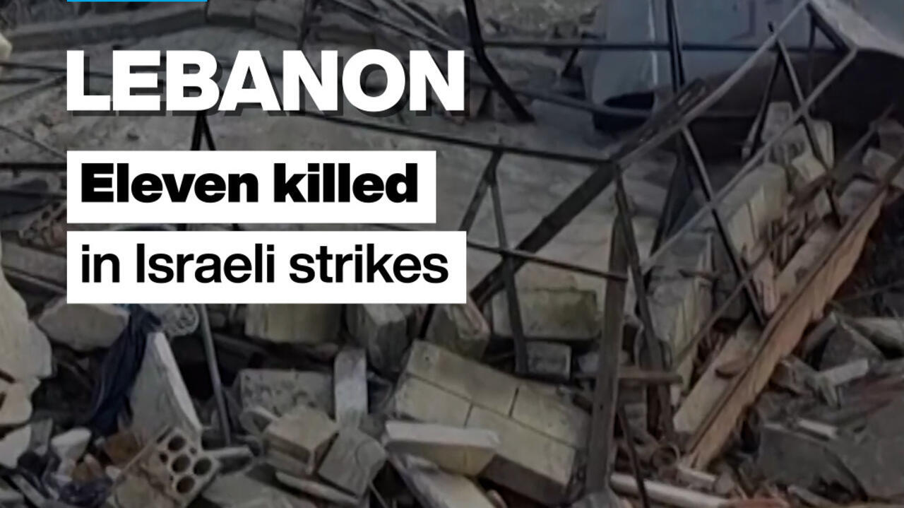 Rubble and damaged structures at a debris-strewn site with overlaid headline text