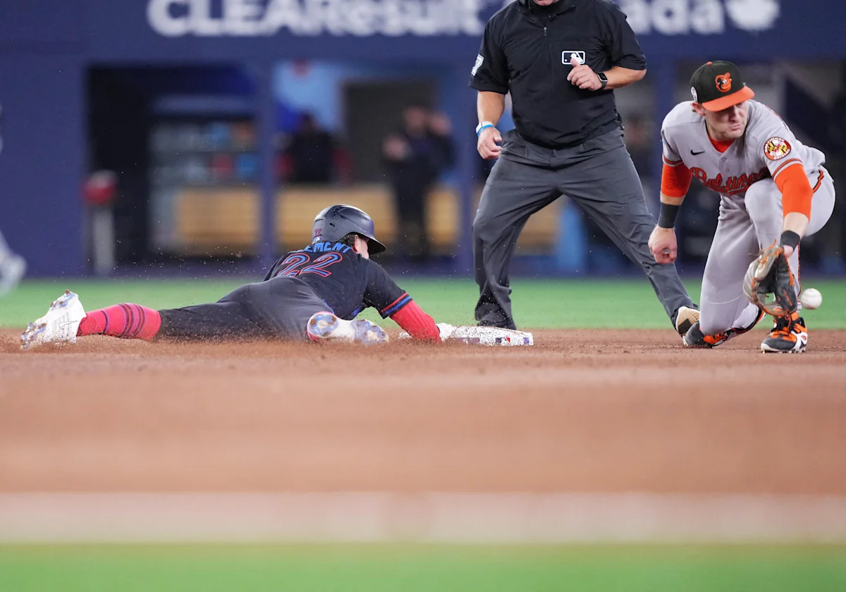 Base runner dives toward second base as an Orioles infielder reaches for the ball.