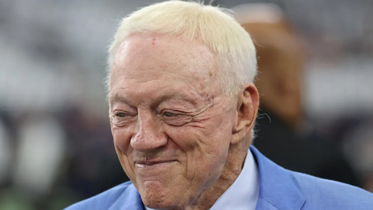 Close-up of an older man with white hair wearing a blue jacket and light shirt.