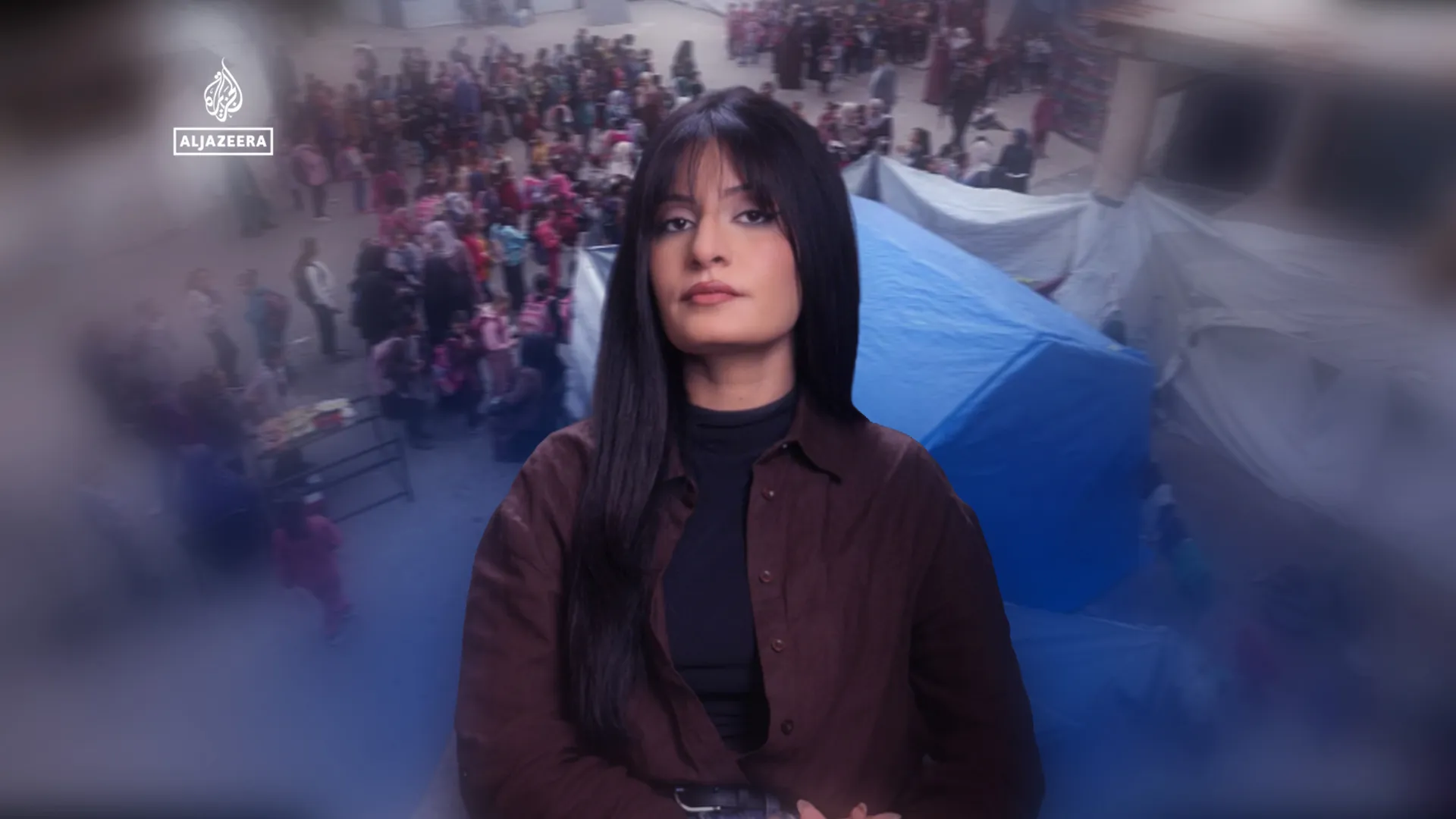 Female presenter stands before a blurred crowd and blue tarpaulin-covered area.
