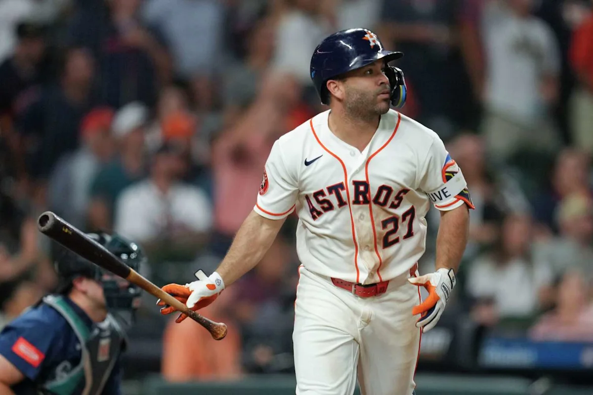 Houston Astros batter in helmet and uniform walks past a catcher while holding a bat.