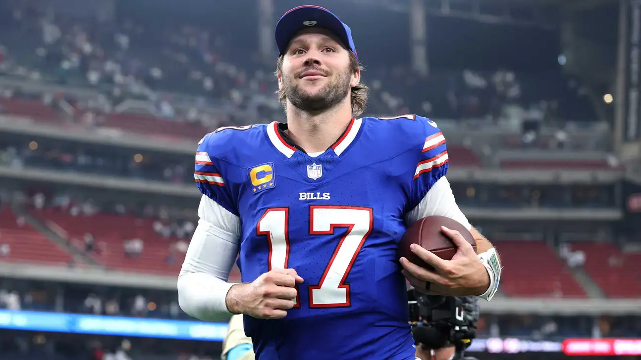 Football player in blue Buffalo Bills jersey holding a football during a game