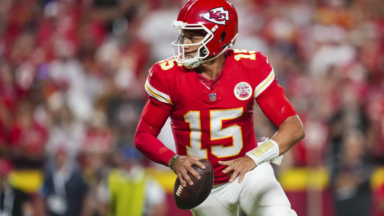 Kansas City Chiefs quarterback in red uniform holds a football during a game.