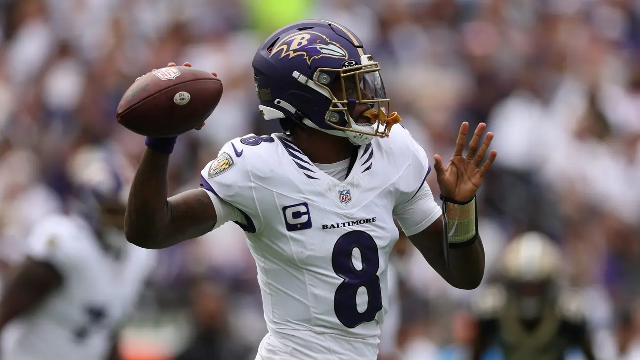Baltimore Ravens player in a white number 8 jersey holds a football before a throw.