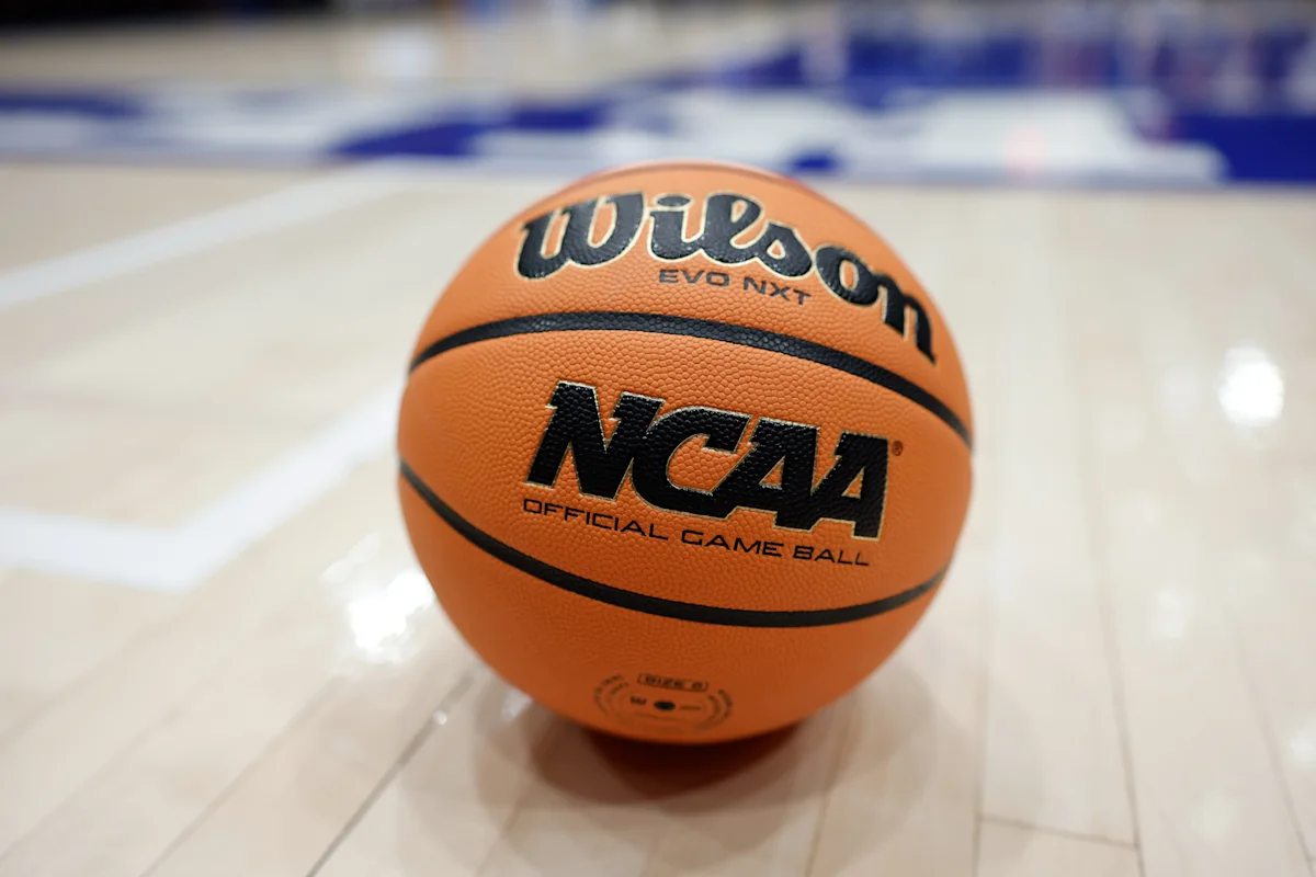 NCAA basketball resting on a polished indoor basketball court