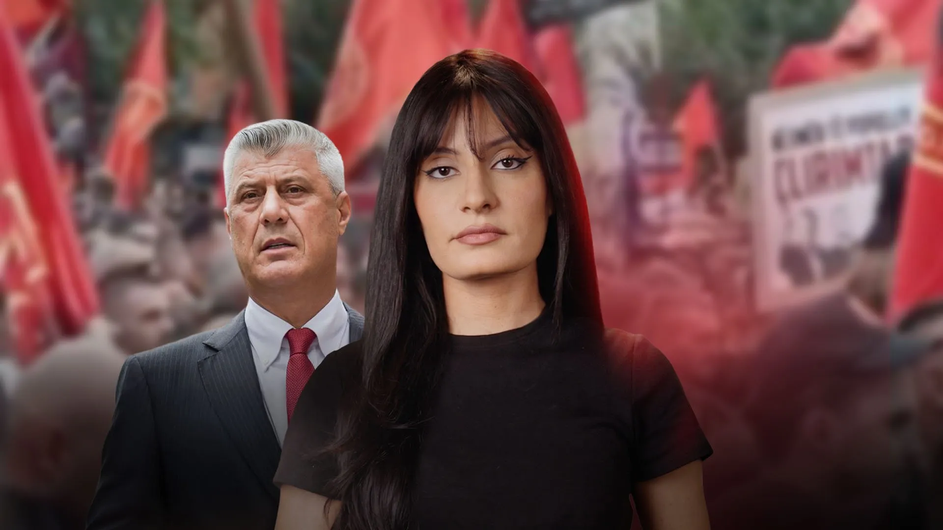 Woman in black standing before suited man amid a blurred crowd holding red flags and signs