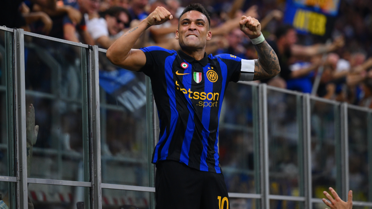 Inter player in blue-and-black jersey celebrates with raised fists before cheering supporters