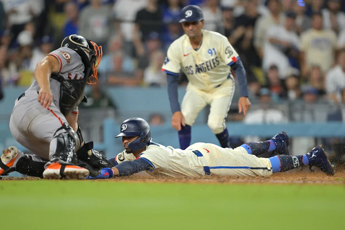 Base runner dives toward home plate as catcher reaches for the ball during a baseball game.