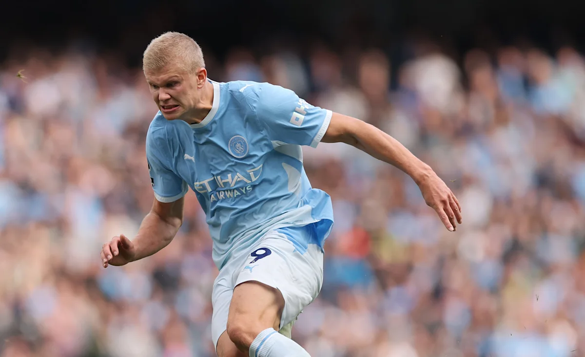 Manchester City player in a sky-blue kit runs forward during a football match