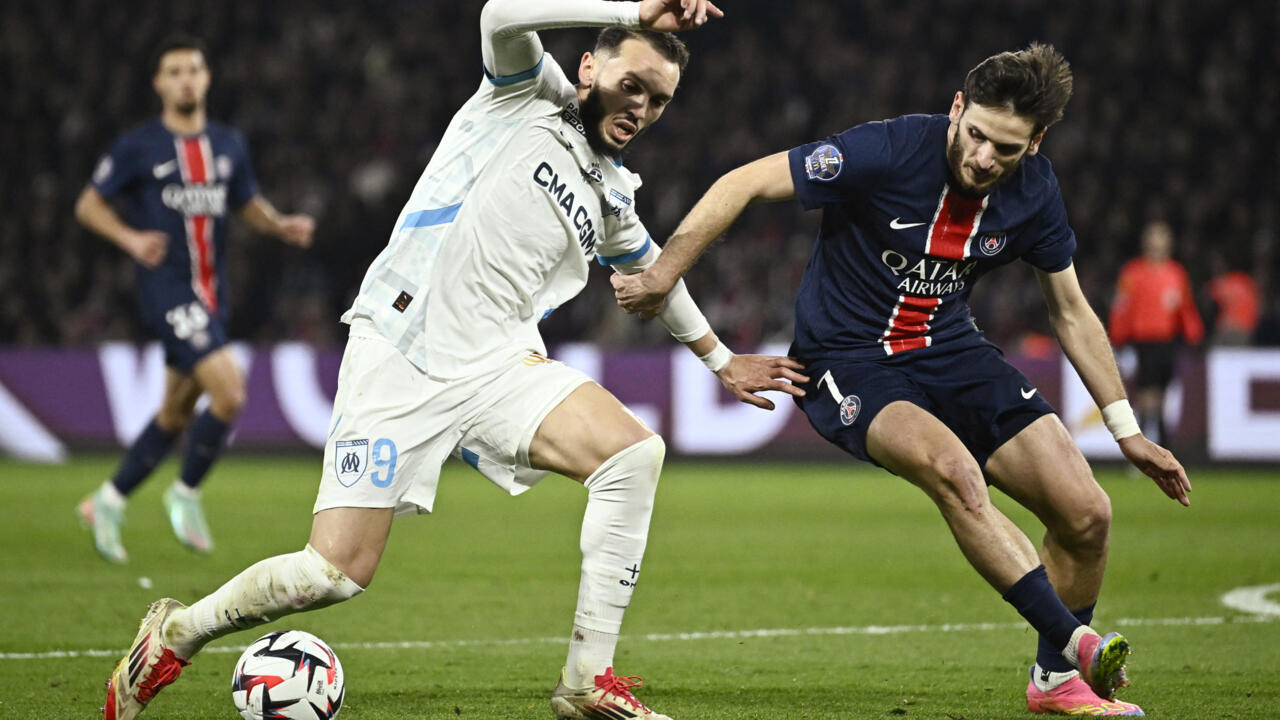 Two football players in PSG and Marseille kits contest the ball during a match.