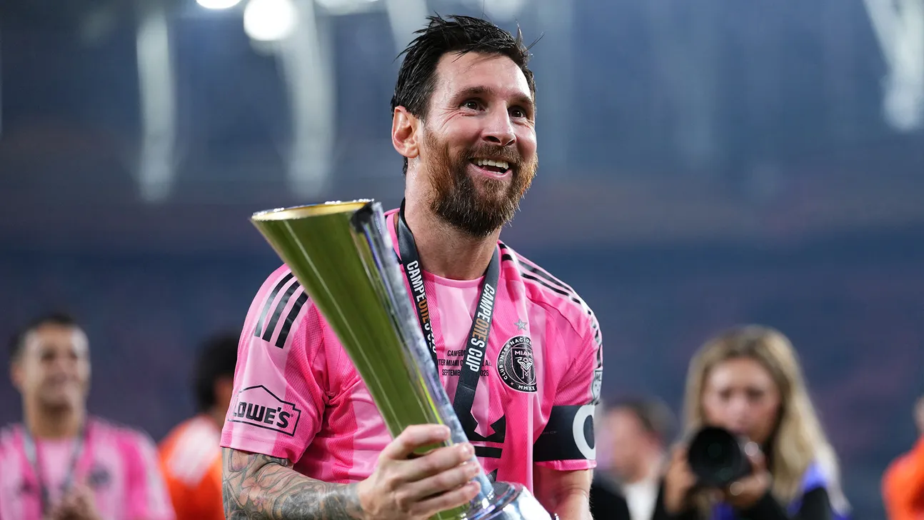 Lionel Messi holds a trophy while wearing Inter Miami’s pink jersey during a celebration