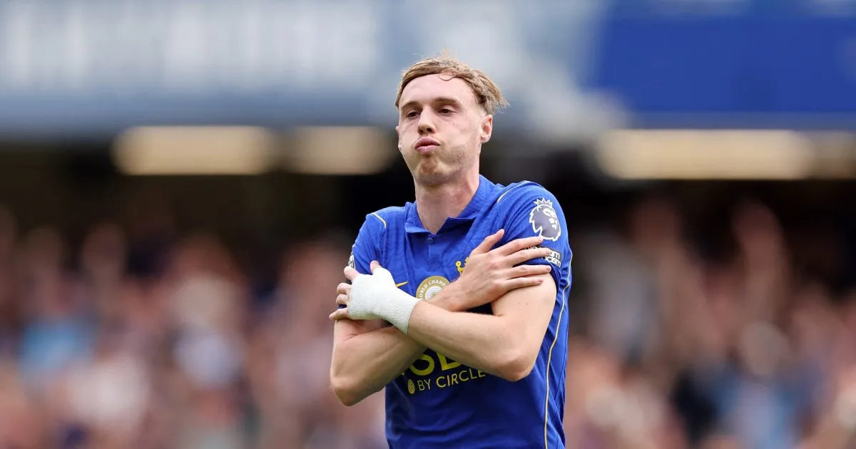 Chelsea footballer in blue shirt celebrates with arms crossed during a Premier League match