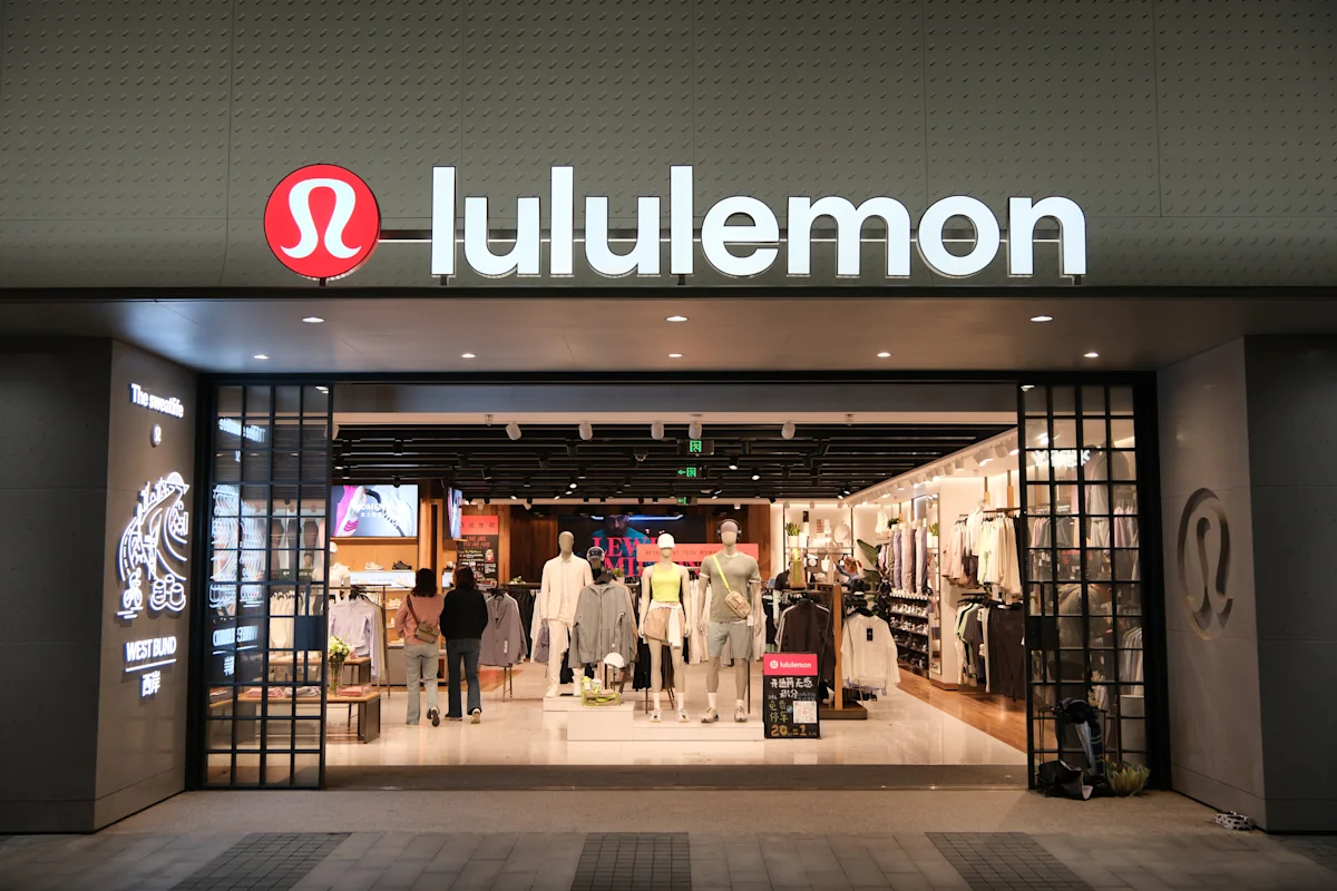 Lululemon storefront with illuminated logo and clothing displays visible through the entrance.