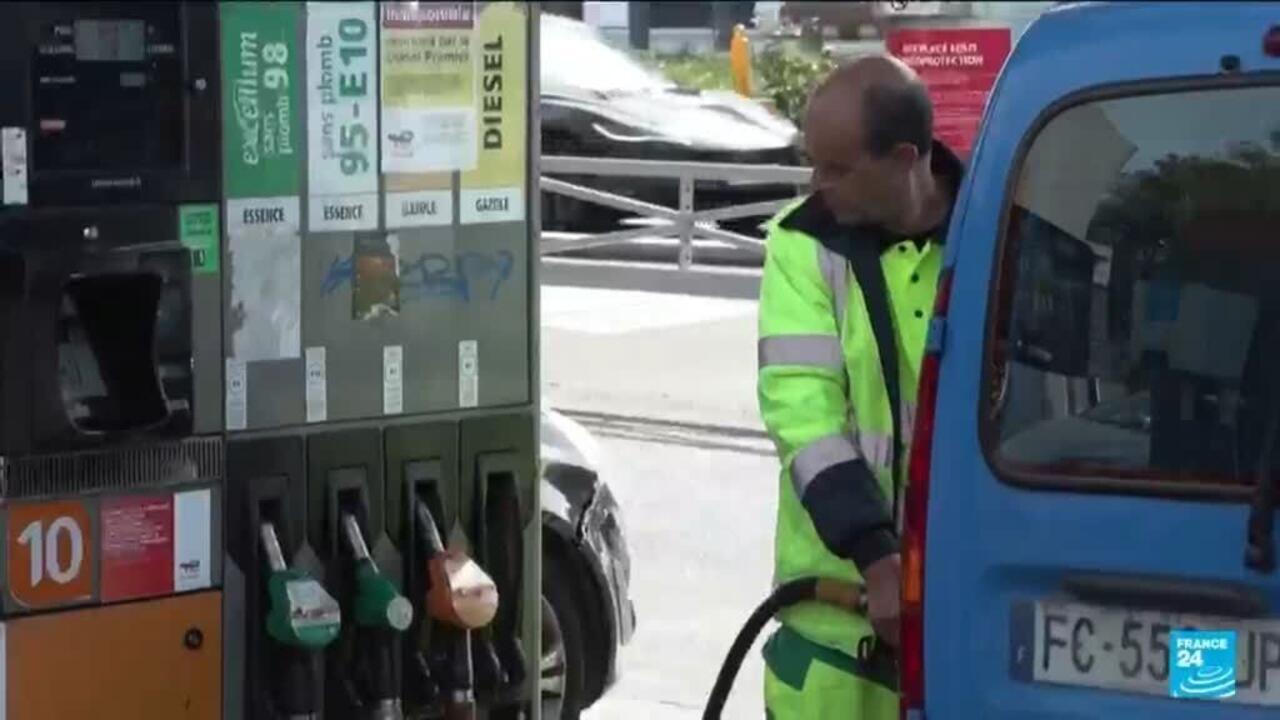 Fuel station worker refueling a blue van beside petrol and diesel pumps