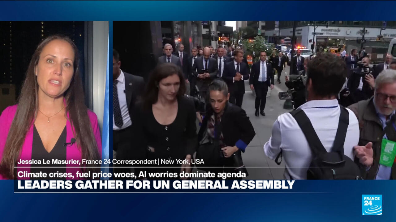 Television news split-screen shows a female correspondent beside officials walking through a busy city street.
