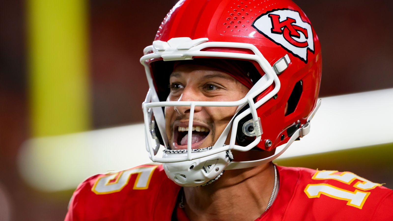 Football player in a red helmet and jersey celebrates during a game.