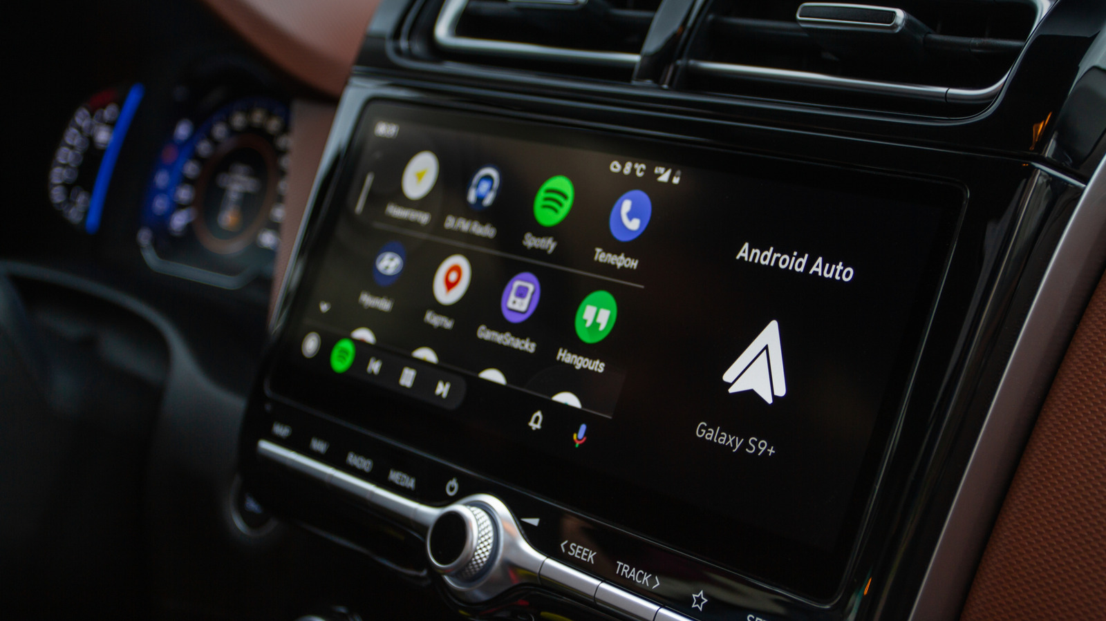 Car dashboard touchscreen displaying Android Auto apps, navigation, phone connection, and vehicle controls