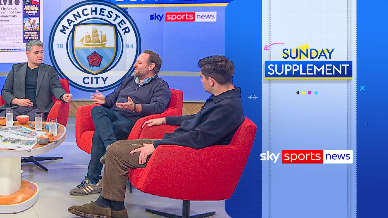 Three men discuss football on a television set beside a large Manchester City crest and Sunday Supplement graphic.
