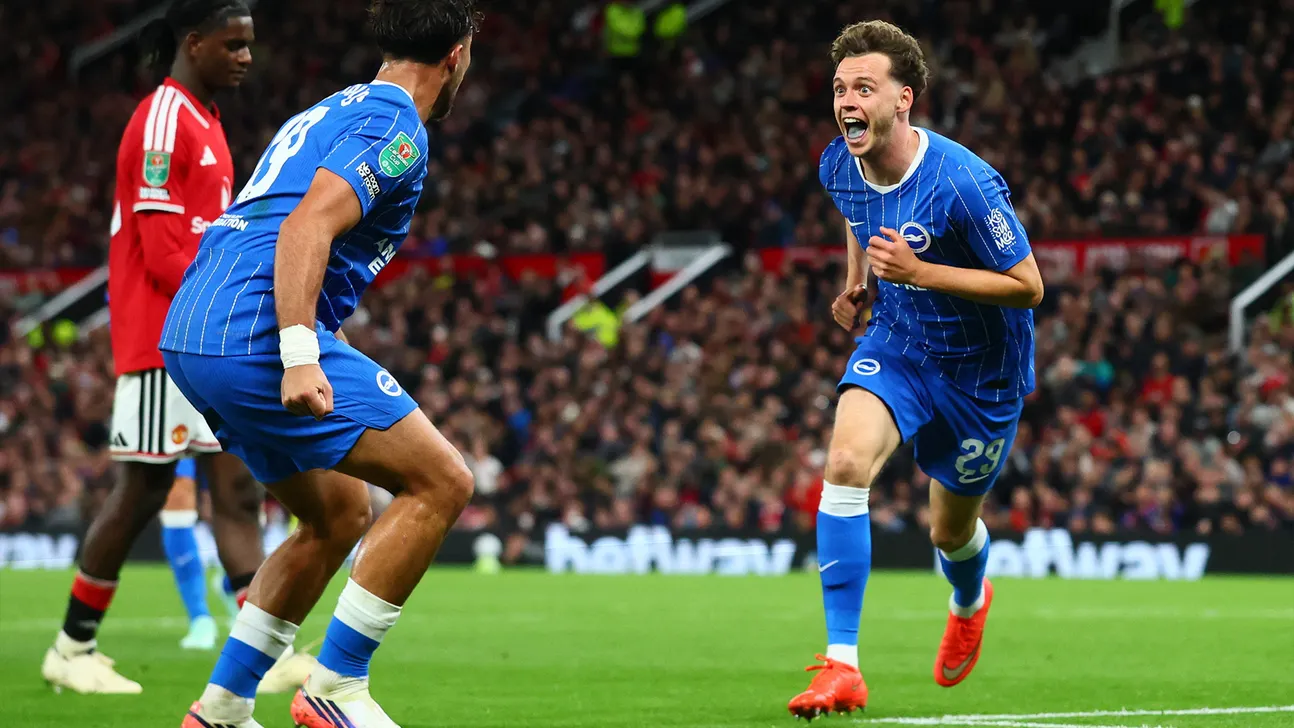 Brighton players in blue celebrate during a football match against Manchester United players in red
