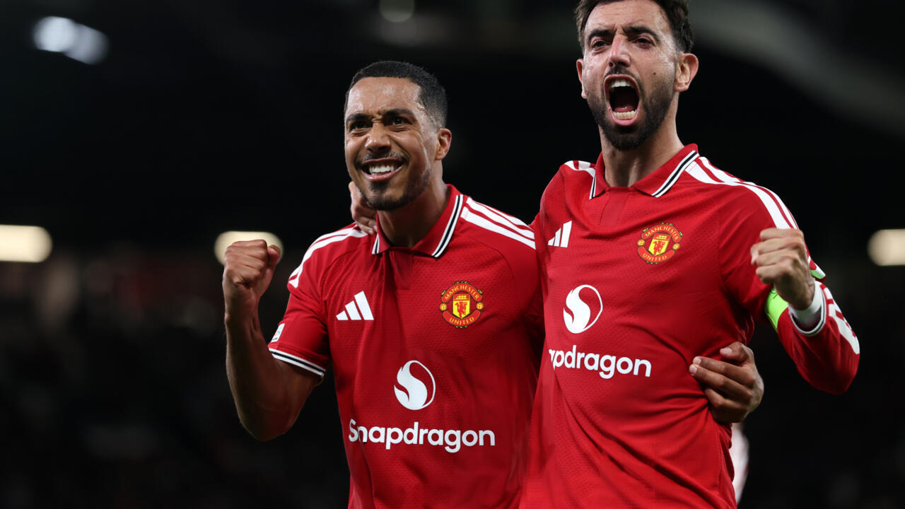 Two Manchester United players in red jerseys celebrate during a football match