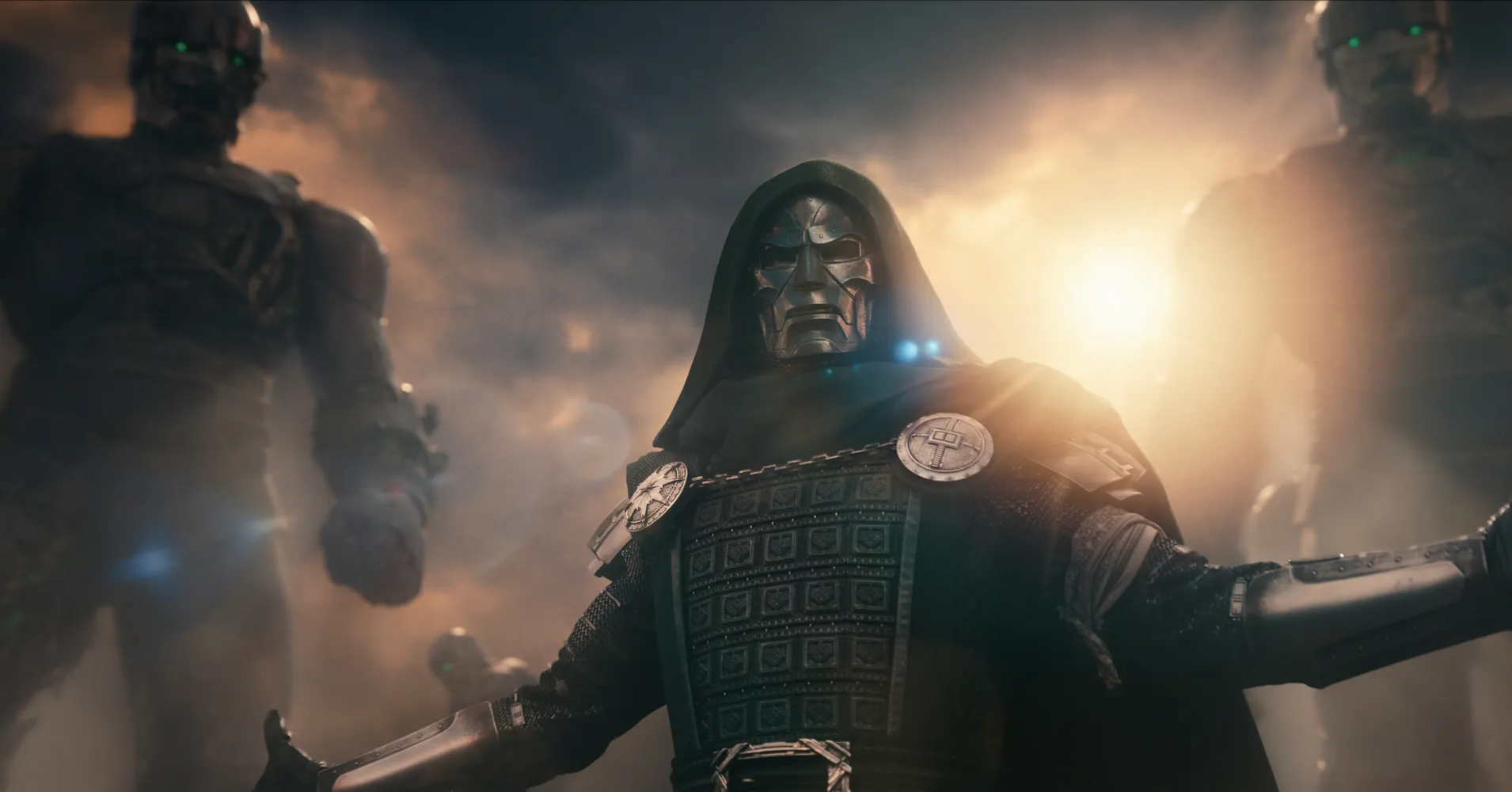 Hooded armored figure stands amid smoke and bright backlight, flanked by shadowy robotic figures.