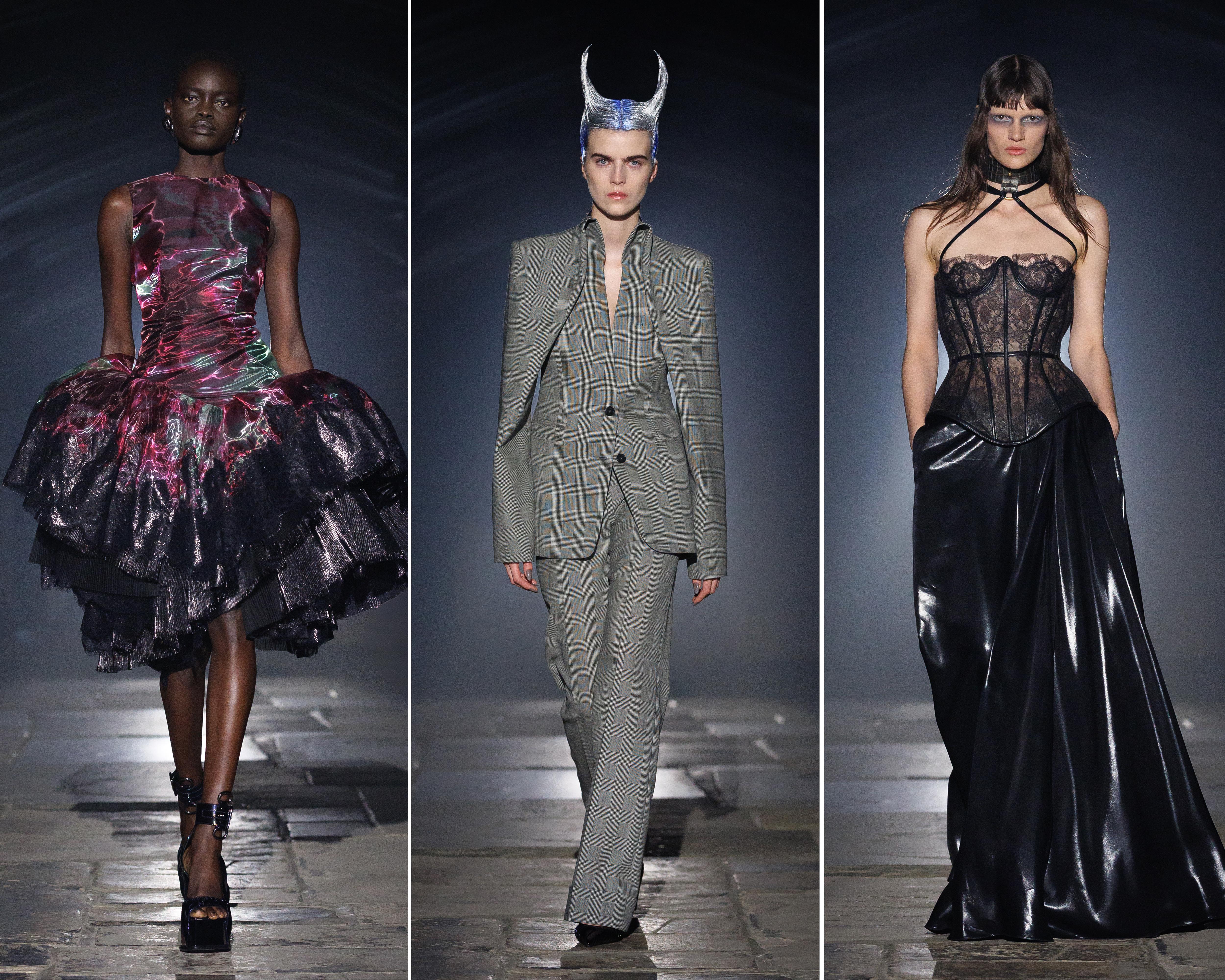 Three fashion models walk a runway in dramatic metallic, tailored, lace and black vinyl looks.