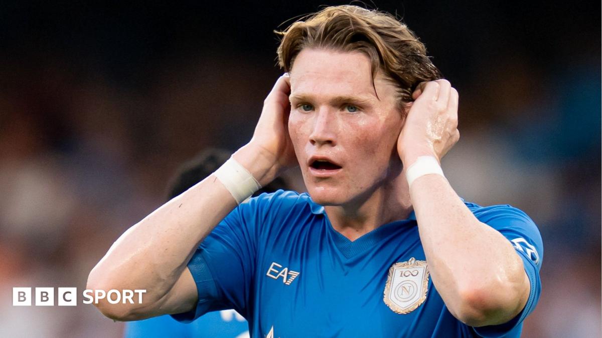 Footballer in blue jersey holds his head with both hands during a match