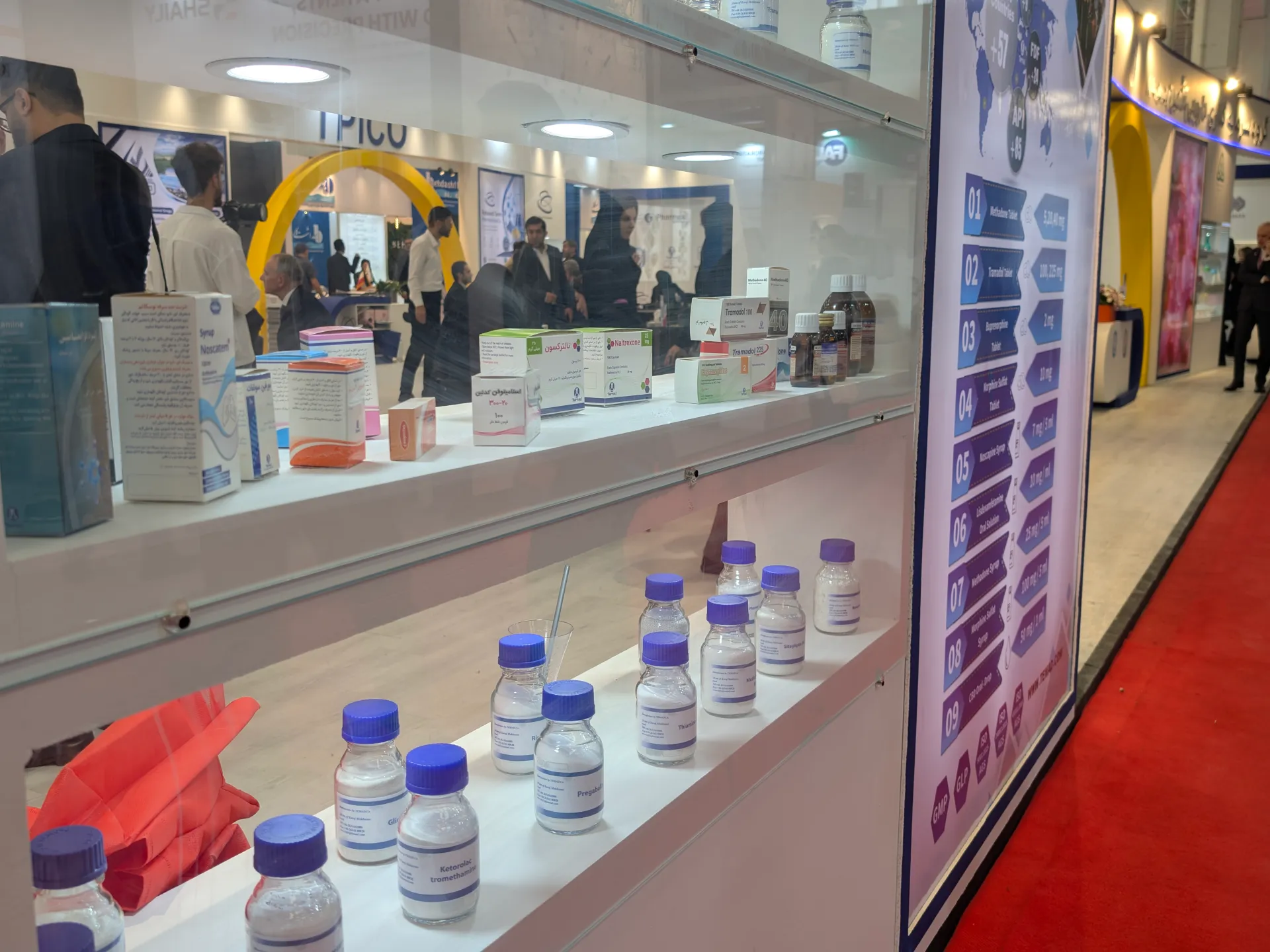 Medicine boxes and vials displayed behind glass at a pharmaceutical exhibition