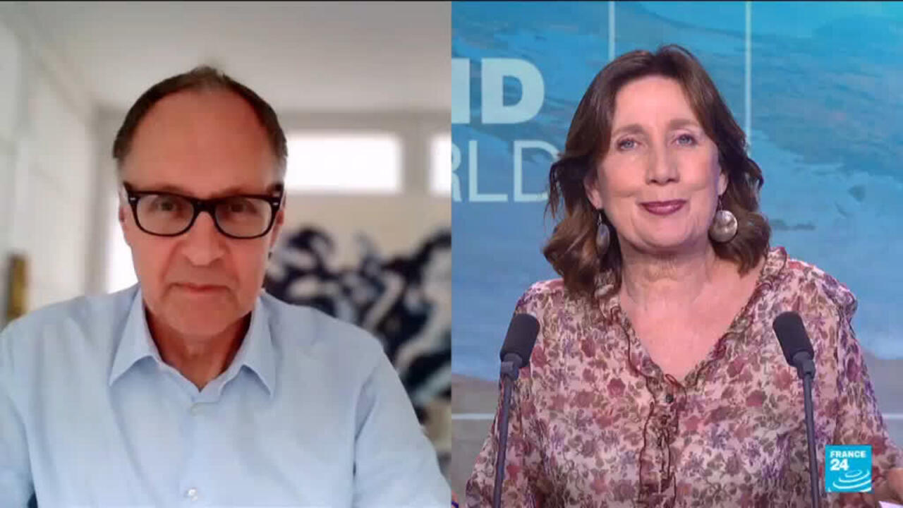 Split-screen interview showing a man in glasses and a woman speaking at a news studio desk.