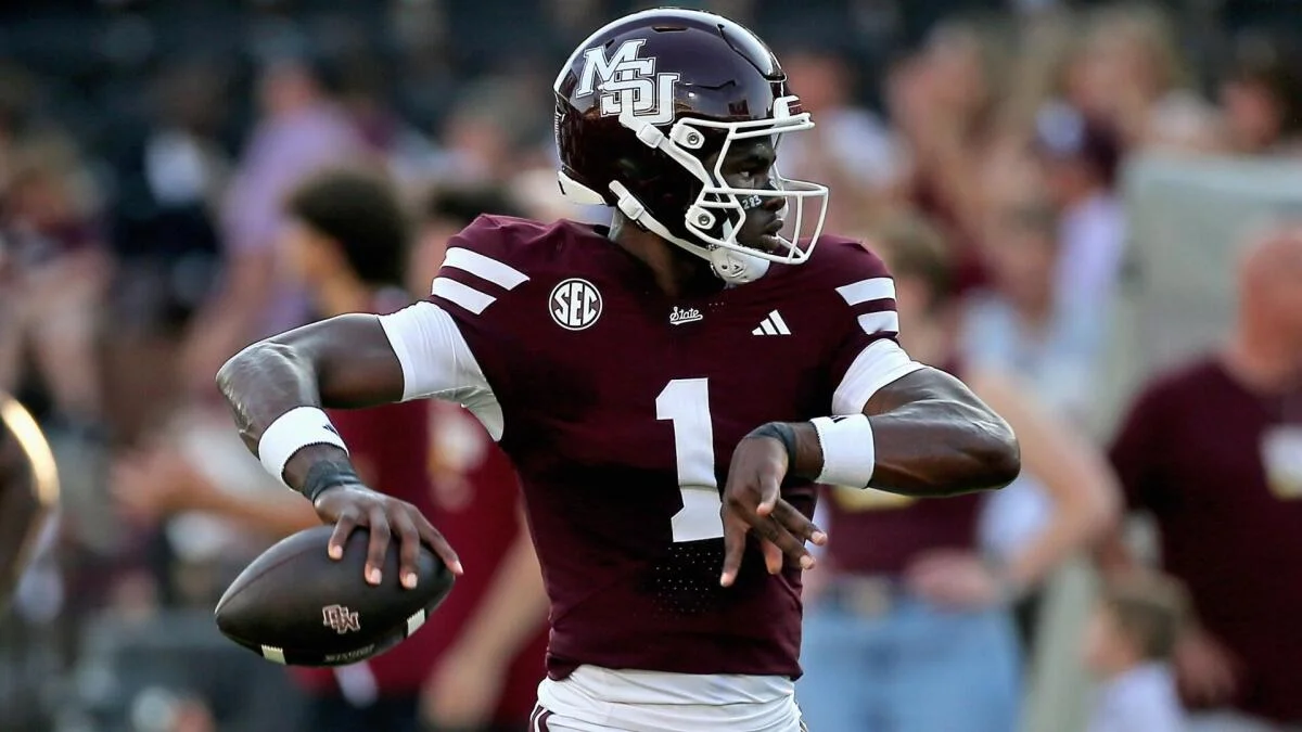 Mississippi State football player in maroon jersey holding a football during a game