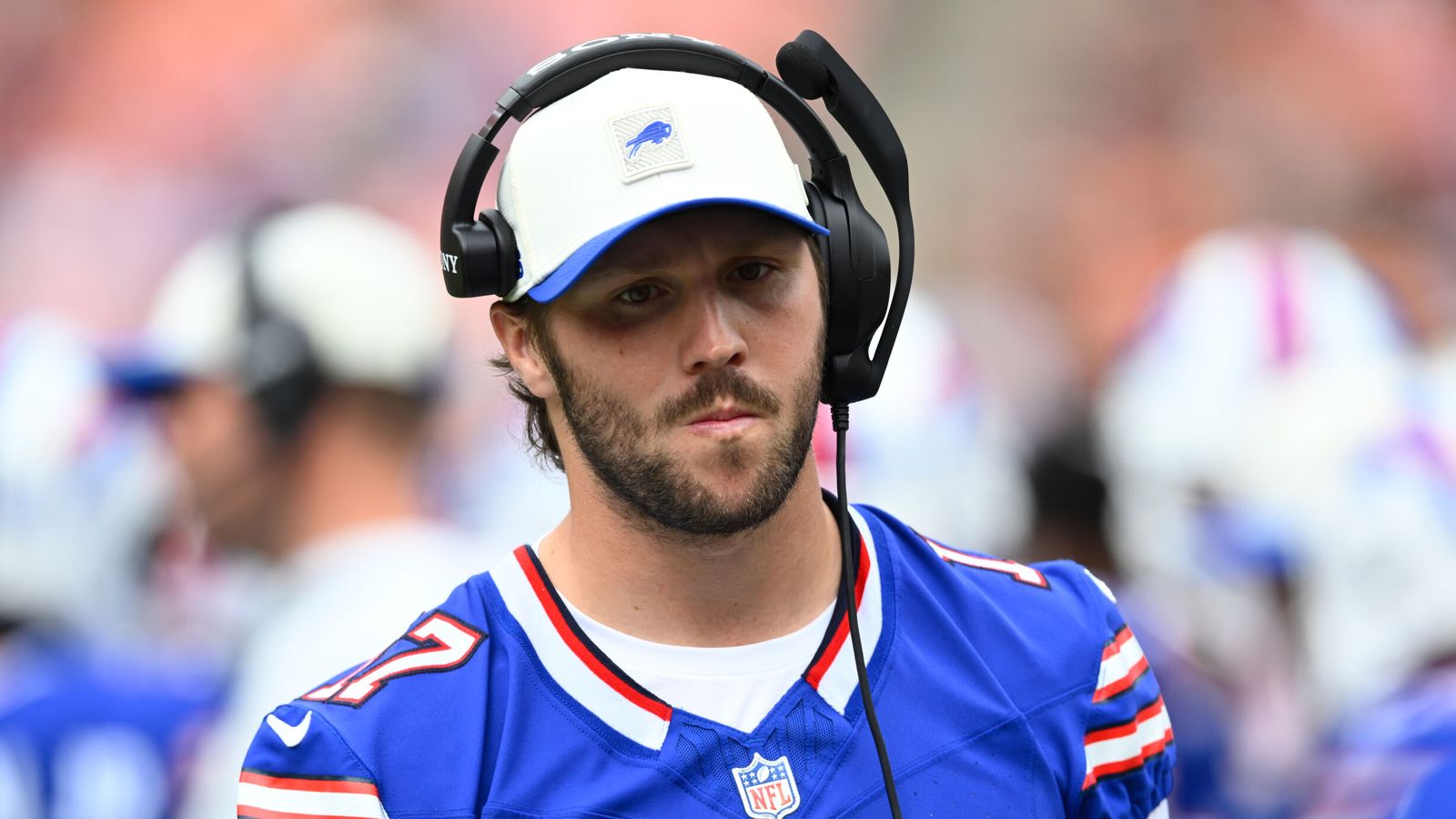 Buffalo Bills quarterback wearing a helmet headset and blue jersey on the sideline
