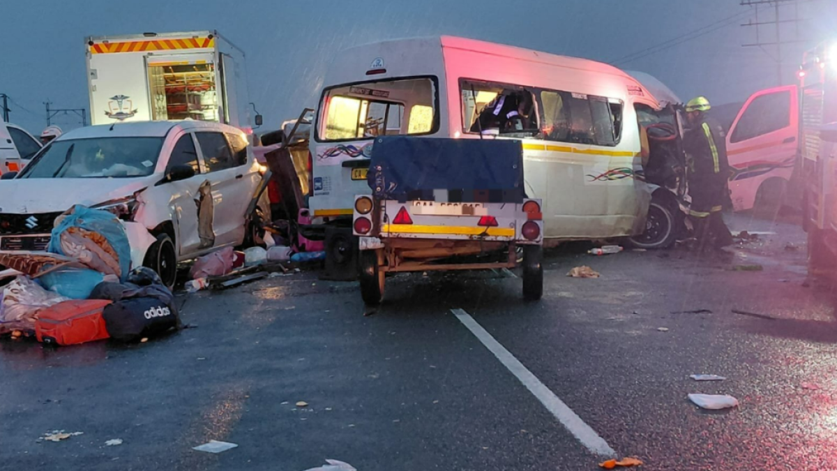 Damaged vehicles and emergency responders at a nighttime multi-vehicle highway crash scene