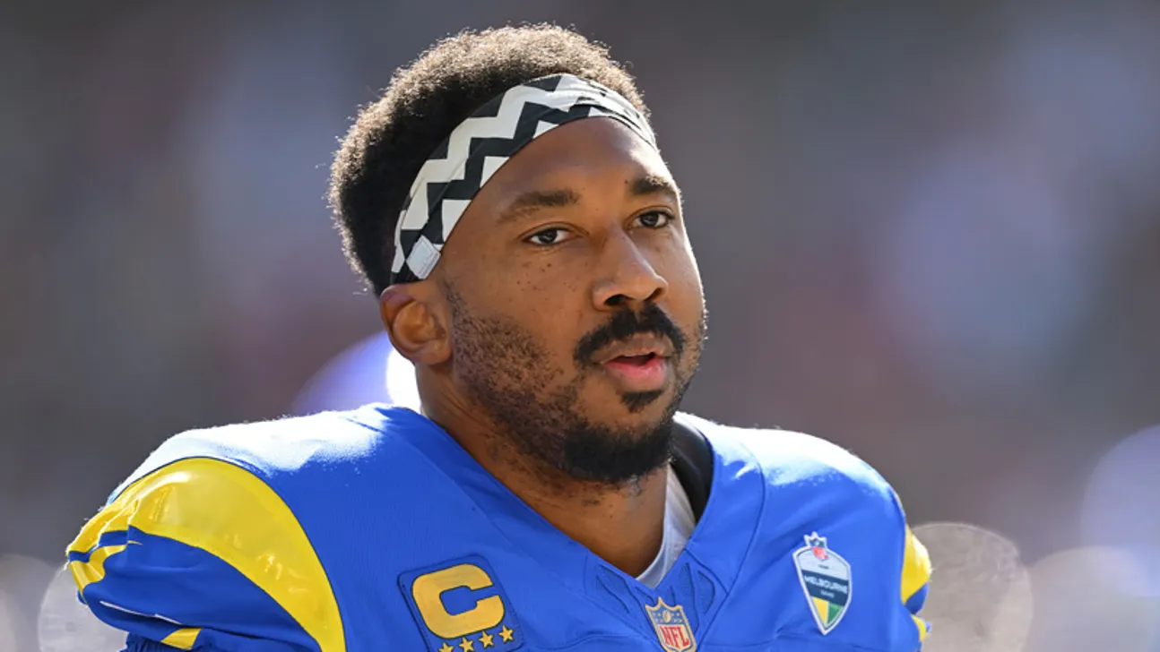 Football player in blue and yellow uniform wearing a patterned headband during a game