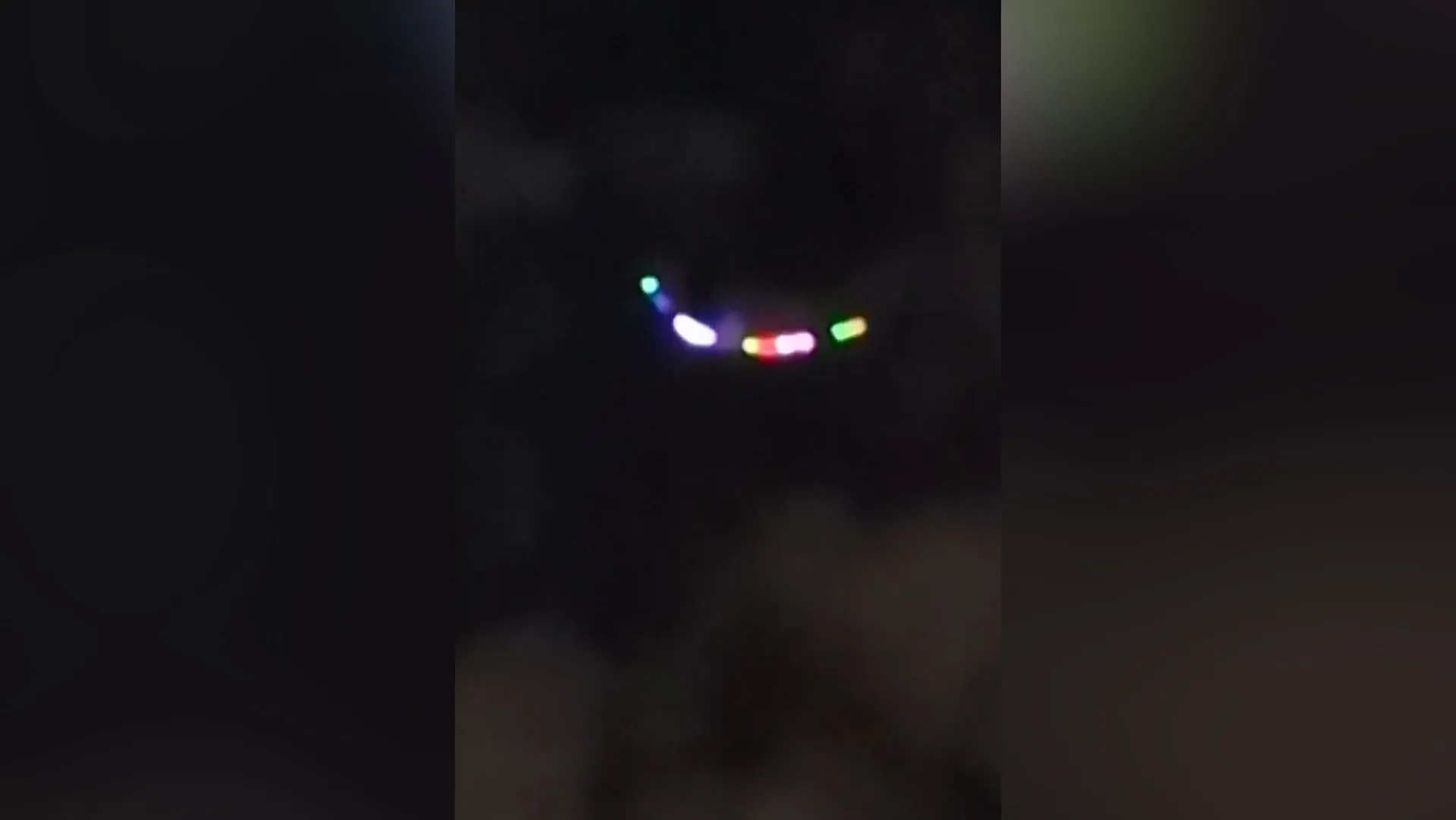 Blurry multicolored lights appear suspended against a dark nighttime background.