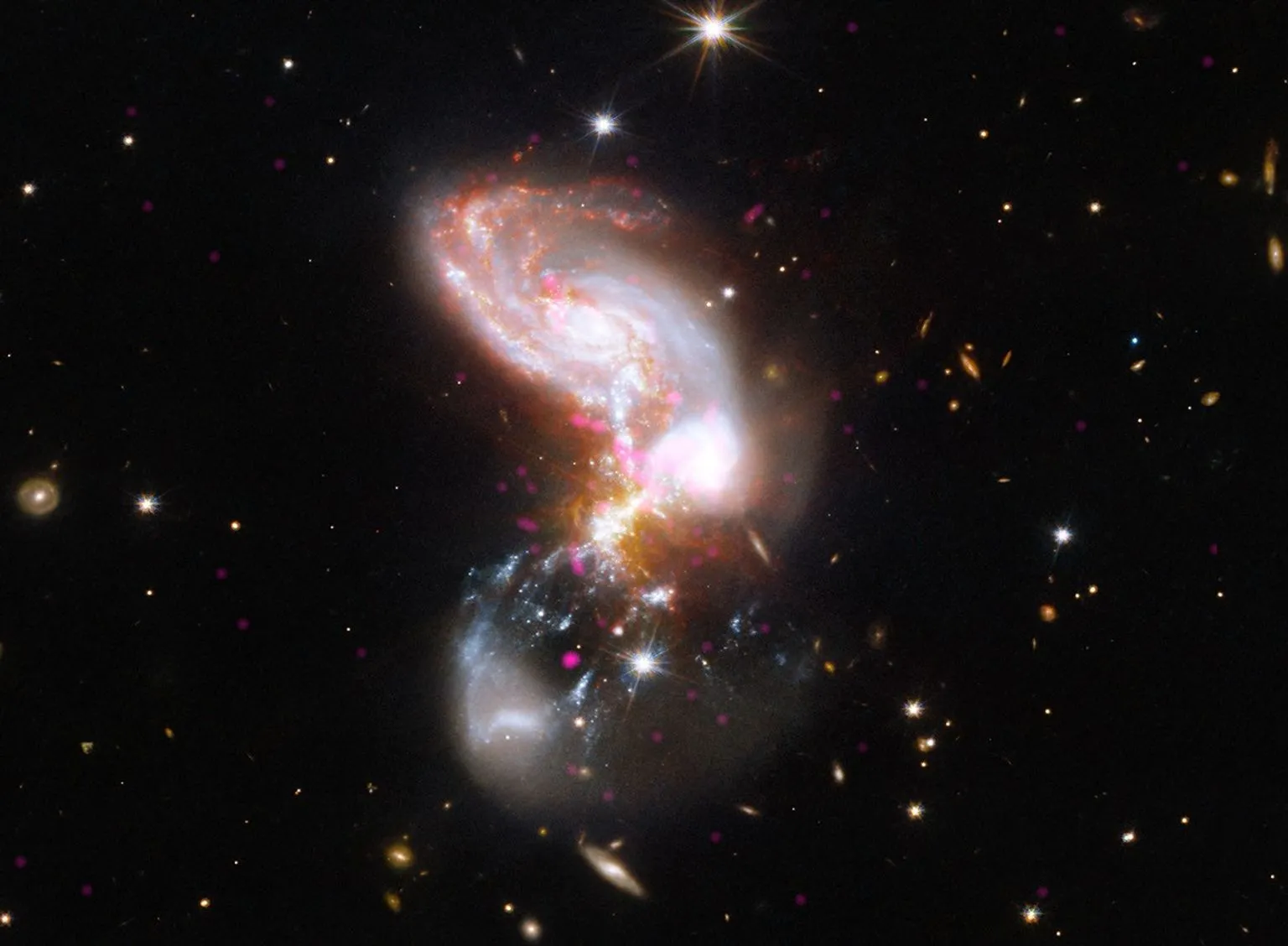 Bright interacting galaxies glowing white, pink, and orange against a dark, star-filled background