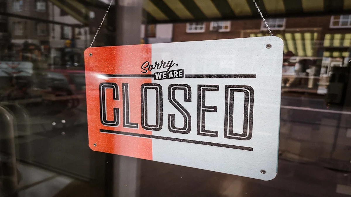 A “CLOSED” sign hangs in a shop window, reflected against a street scene.
