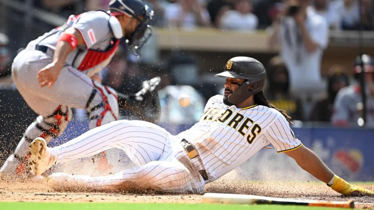 Padres runner slides into home as catcher reaches toward the incoming baseball.