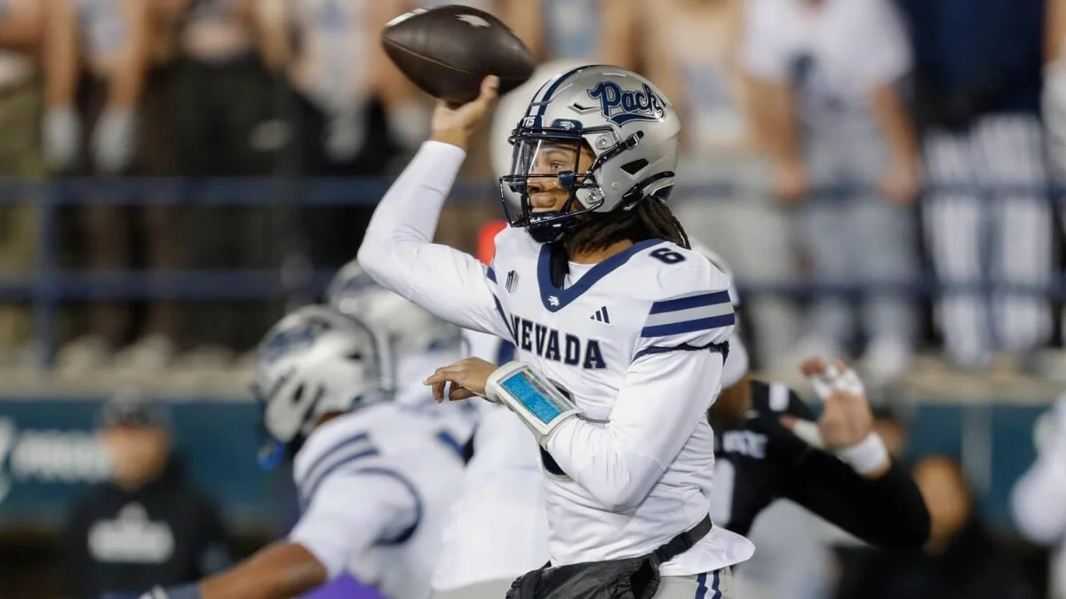 Nevada quarterback in a white uniform throws a football during a game.
