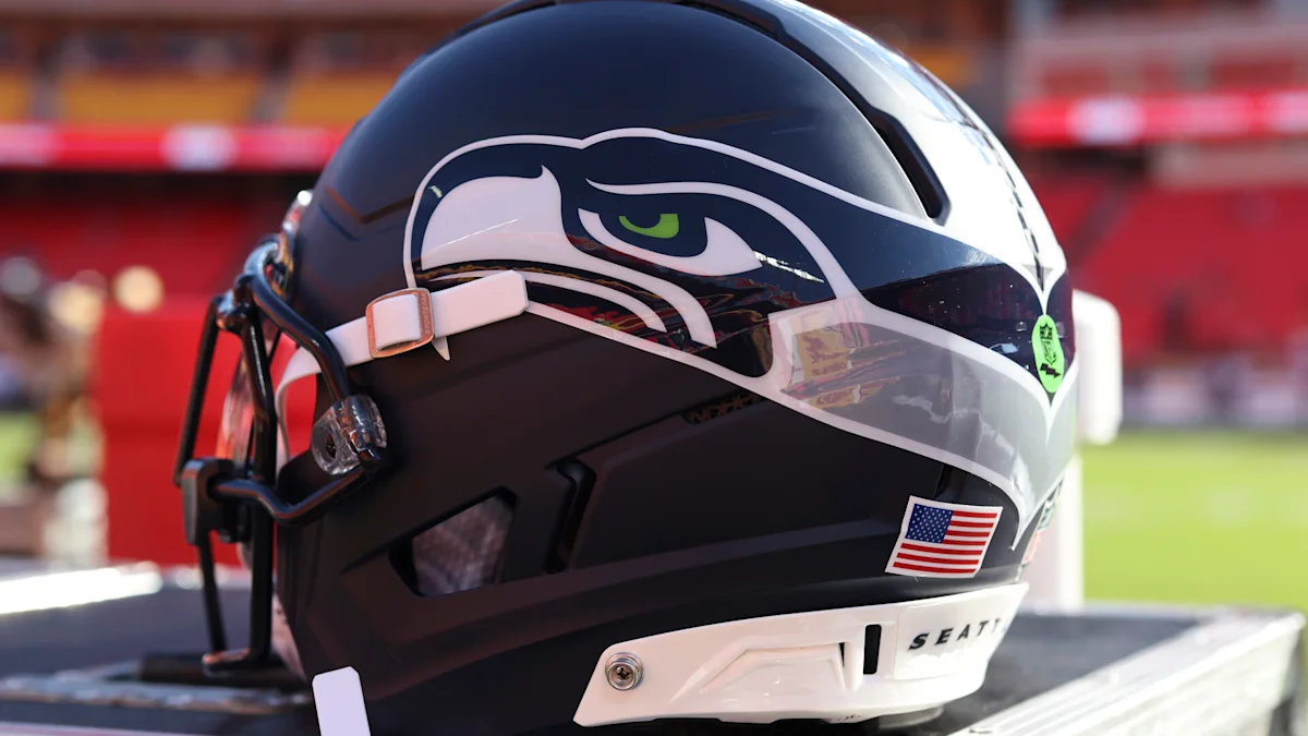 Seattle Seahawks football helmet resting on a bench with a blurred stadium background