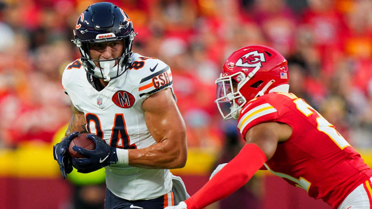 Chicago Bears player carries the football as a Kansas City Chiefs defender closes in.
