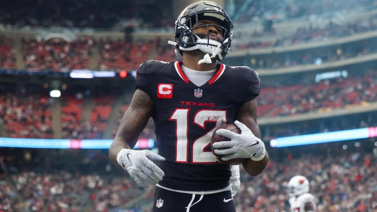 Houston Texans player wearing number 12 holds a football during a game.