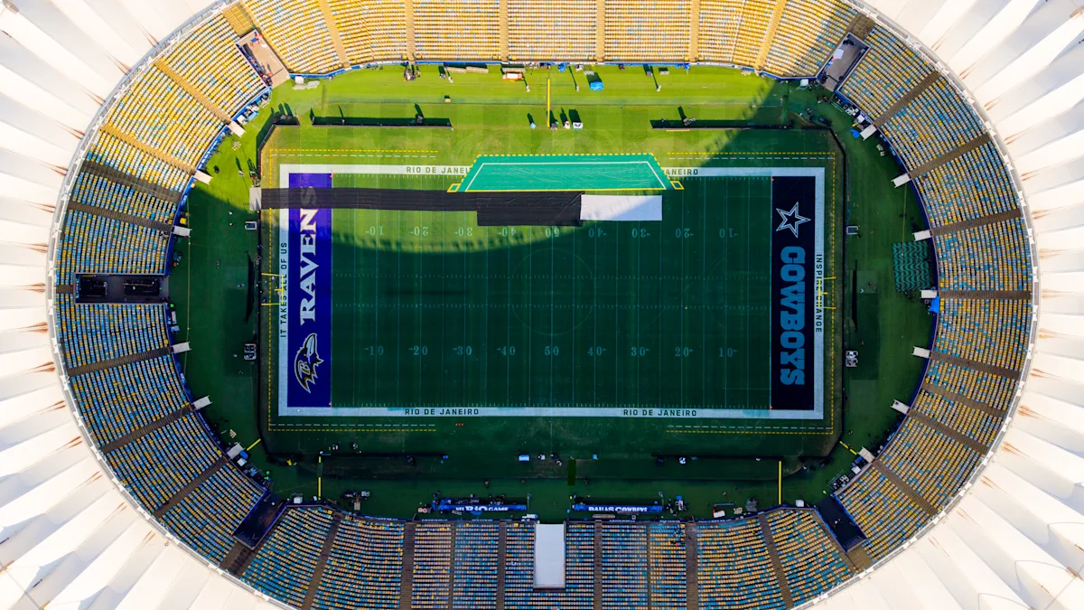 Aerial view of a football field with Cowboys and Ravens end zones inside a stadium.